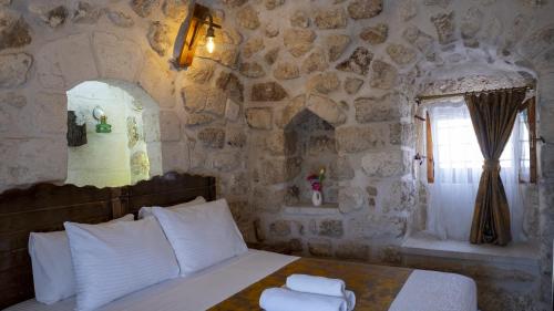 a bedroom with a bed in a stone wall at Mons Masius Hotel Teras in Midyat