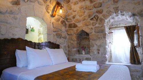 a bedroom with a bed with towels on it at Mons Masius Hotel Teras in Midyat