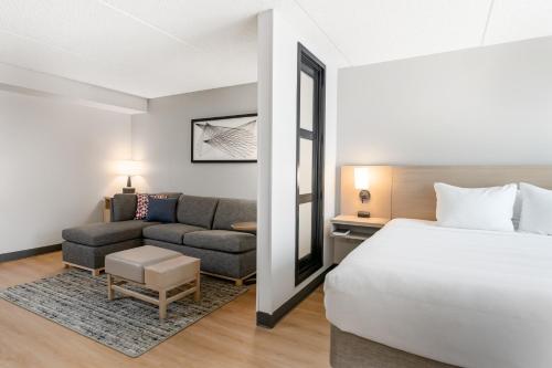 a hotel room with a bed and a couch at Hyatt Place College Station in College Station