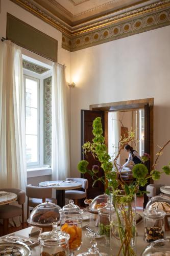 a dining room with a table and a mirror at Palazzo Firenze by Baglioni Hotels & Resorts in Florence