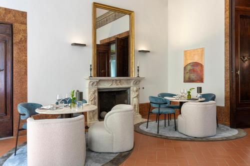 a dining room with two tables and a mirror at Palazzo Firenze by Baglioni Hotels & Resorts in Florence