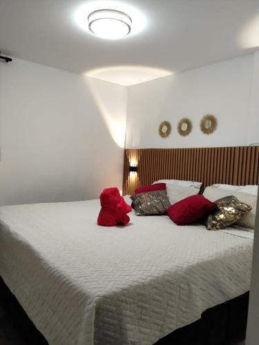 a bedroom with a large bed with red pillows at We Rent VIP - San Julián in Medellín