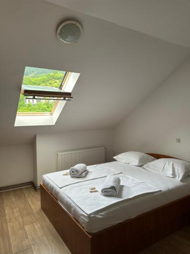a bedroom with a large bed with a window at Restoran Orahovica Konjic - sobe in Konjic