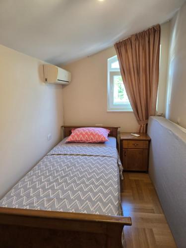 a small bedroom with a bed and a window at Sea View Apartment in Bijela