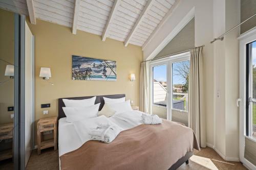a bedroom with a bed with white sheets and a window at Luxuswellnesshaus Ostwind in Bliesdorf