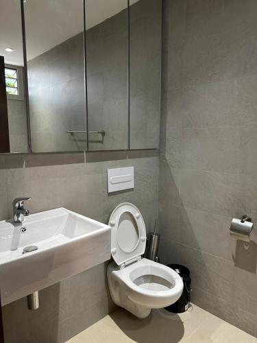 a bathroom with a sink and a toilet and a mirror at Antilia home 1 in Abidjan