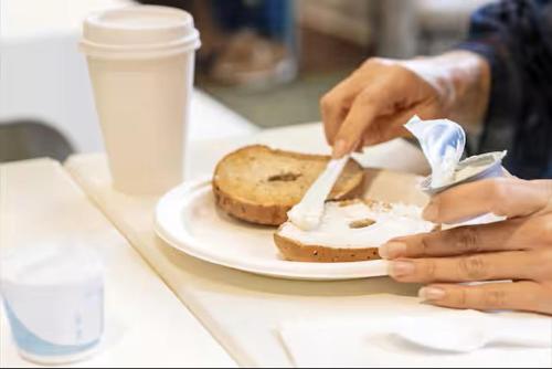 a person eating a piece of bread on a plate at Spark by Hilton Clifton in Clifton