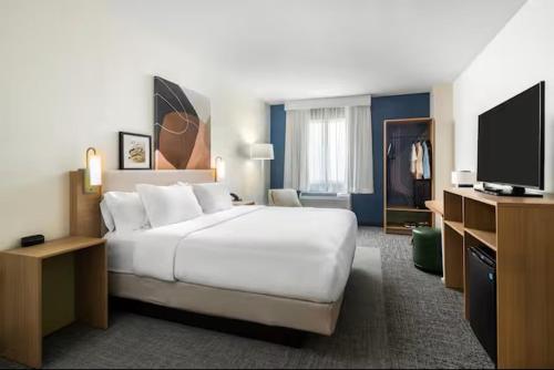 a hotel room with a large bed and a flat screen tv at Spark by Hilton Clifton in Clifton