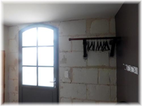 a room with a door and a brick wall at Le Gîte des Marguerites in Montrichard