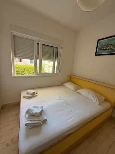 a bedroom with a bed with towels on it at Apartman sa dve spavace sobe, prizemlje, Popović in Petrovac na Moru