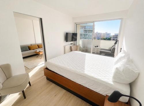 a bedroom with a bed and a large window at ideal in Carnon-Plage