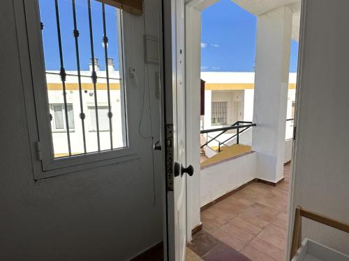 an open door with a view of a balcony at Los Pescadores Playa Sol in Novo Sancti Petri