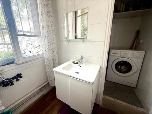 a bathroom with a sink and a washing machine at paris kiffe in Villejuif