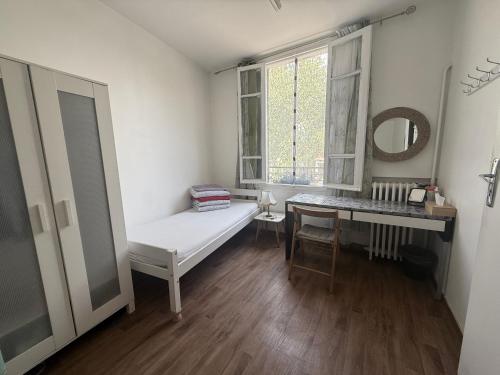 a white room with a bench and a table and a mirror at paris kiffe in Villejuif
