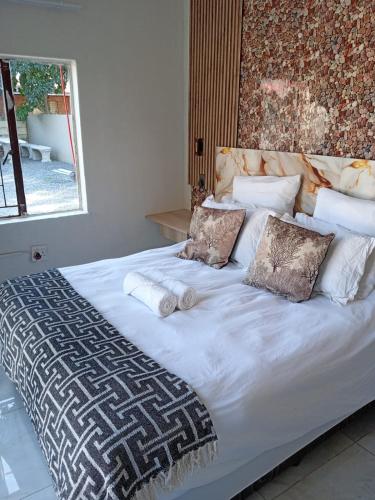 a large white bed with pillows on top of it at MRH Self Check- In Express Homestay in Modimolle