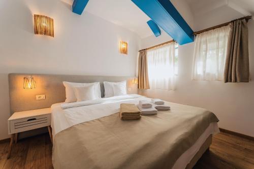a bedroom with a large bed with two towels on it at Cherhana Resort in Crisan