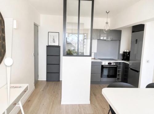 a kitchen with white and gray cabinets and a table at ideal in Carnon-Plage