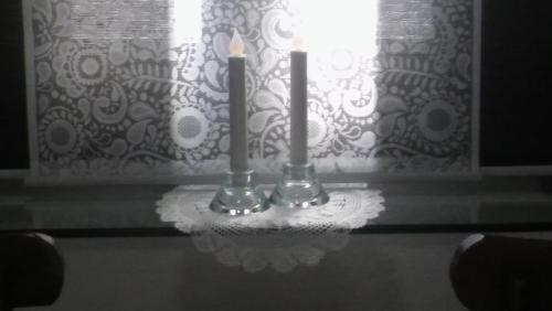 two candles sitting on a table in front of a window at Hotel Dryalos in Miléai
