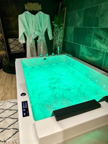 a bath tub with a turquoise at Escale Singulière - Balnéo, patio et confort 4 étoiles in Sète