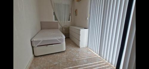 a small white bathroom with a small table and stool at Villa Guzi in Orihuela Costa
