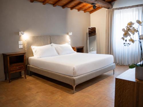 ein Schlafzimmer mit einem großen weißen Bett und einem Fenster in der Unterkunft La Quercetta in Foligno