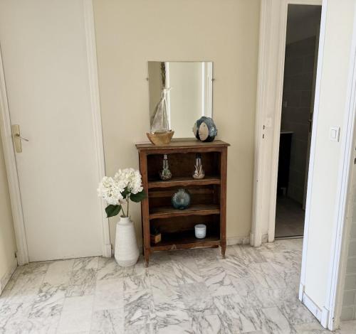 a room with a mirror and a table with flowers at Rives dor 1C in Juan-les-Pins