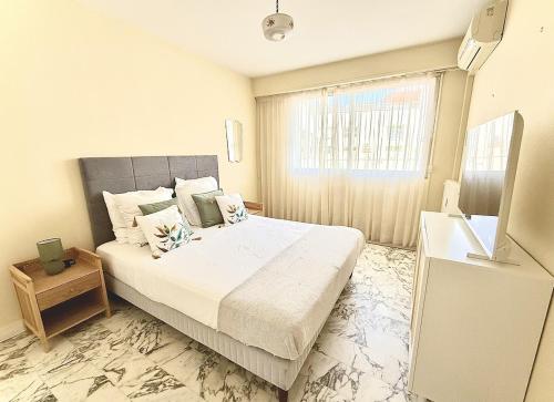 a bedroom with a large bed and a window at Rives dor 1C in Juan-les-Pins