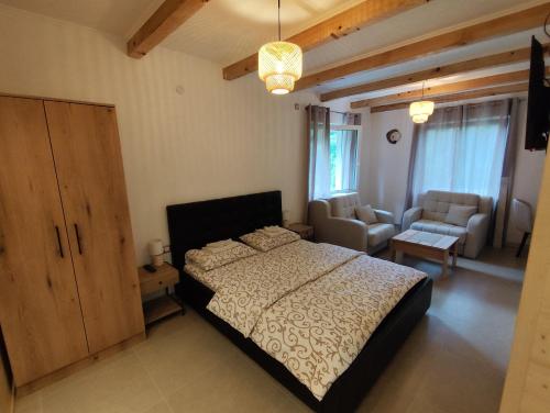 a bedroom with a bed and a living room at Apartments & Rooms Bojic in Kolašin