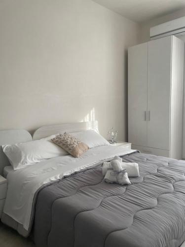 a white bedroom with a bed with a teddy bear on it at La Volta di Chiara in Roccaforzata