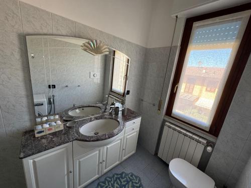a bathroom with a sink and a large mirror at L'ora del tè in Cremona