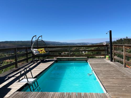 a swimming pool on a wooden deck with a chair at Casinha in Celorico de Basto