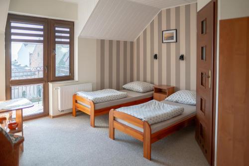 a room with two beds and a window at Pokoje Iza in Chałupy