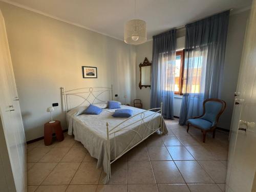 a bedroom with a bed and a blue chair at L'ora del tè in Cremona