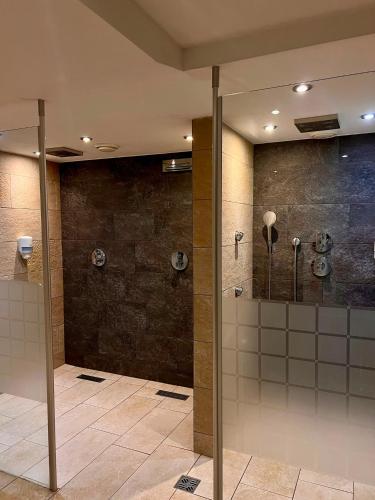 a bathroom with a shower and stalls in a building at Bergsteiger-Zimmer Pension Obermair in Mayrhofen