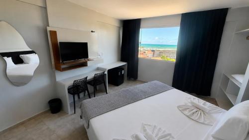 a hotel room with a bed and a view of the ocean at Atlas Beach Hotel in Fortaleza
