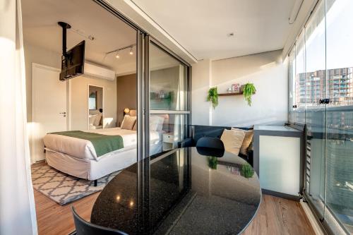 a room with a bed and a glass table at Movinn Nine - Jardim Paulista in São Paulo
