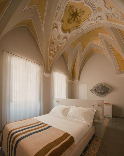 a bedroom with a large bed with an ornate ceiling at Sant'Angelo Ostuni - Il Palazzo in Ostuni