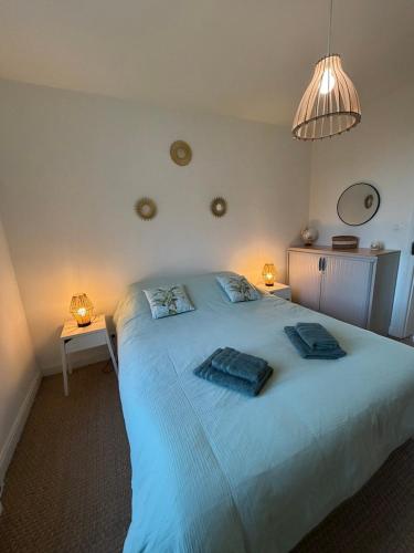 a bedroom with a large bed with two towels on it at Les chtis voyageurs appartement 2 chambres terrasse in Marcq-en-Baroeul