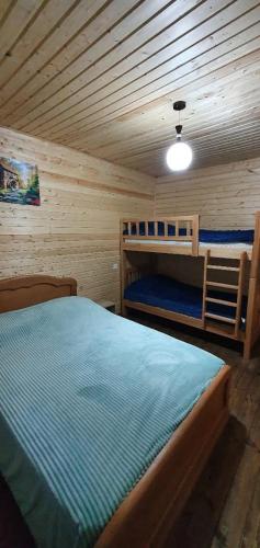 a bedroom with two bunk beds in a cabin at Midamo in Manglisi