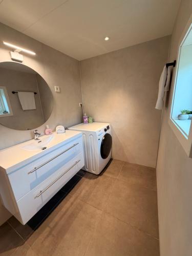 a bathroom with a washing machine and a sink at Reine Viewpoint House in Reine