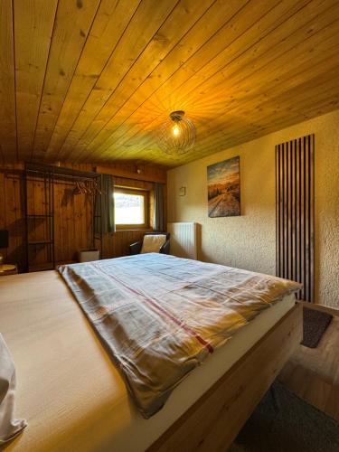a large bed in a room with a wooden ceiling at Haus Asslaber in Hochfilzen