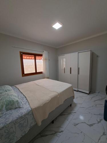 a bedroom with a large bed and a window at Conforto e Tranquilidade, Casa Completa in Martins