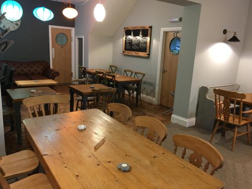 a dining room table and chairs in a room at Portreath Arms in Portreath