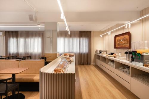 a restaurant with a kitchen and a dining room at Hotel Fiorio in Flores da Cunha