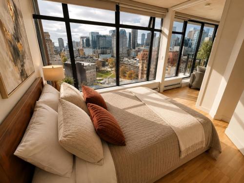 a bedroom with a bed and a large window at Historic Downtown Escape in Vancouver