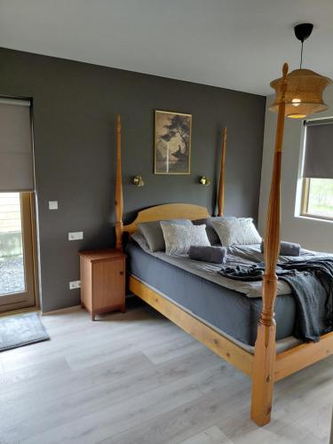 a bedroom with a bed with a wooden frame at Elliðaár Valley Guesthouse in Reykjavík
