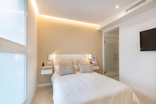 a bedroom with a white bed and a flat screen tv at Maravilloso estudio en pleno centro in Madrid