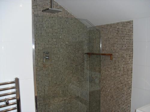 a bathroom with a shower with a glass door at Langland Road B&B in The Mumbles