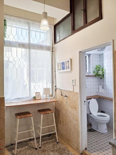 a bathroom with a toilet and two stools at 山露露品茶 6-25人 包層包棟民宿 in Tainan