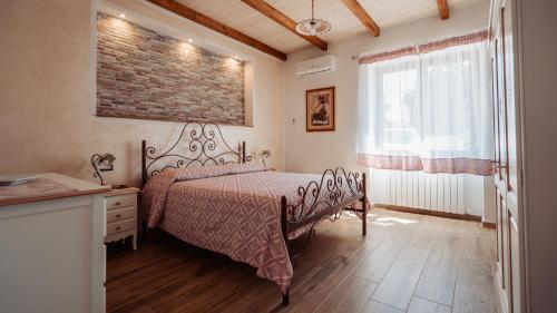 a bedroom with a bed and a brick wall at Casa Vacanze LA CIMINEA in Erula